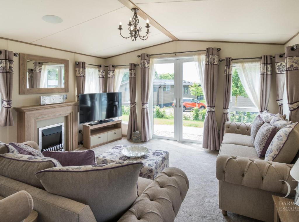 a living room with two couches and a tv at Valley View with a luxurious hot tub in Newquay