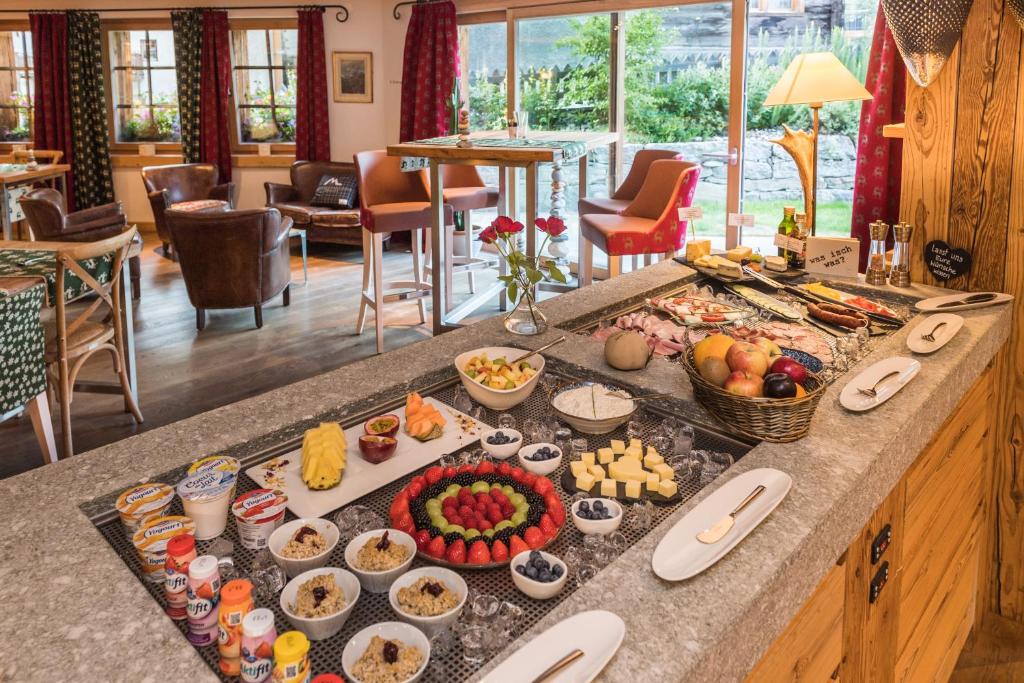 a buffet with many different types of food on a counter at Matterhorn Lodge Boutique Hotel & Apartments in Zermatt