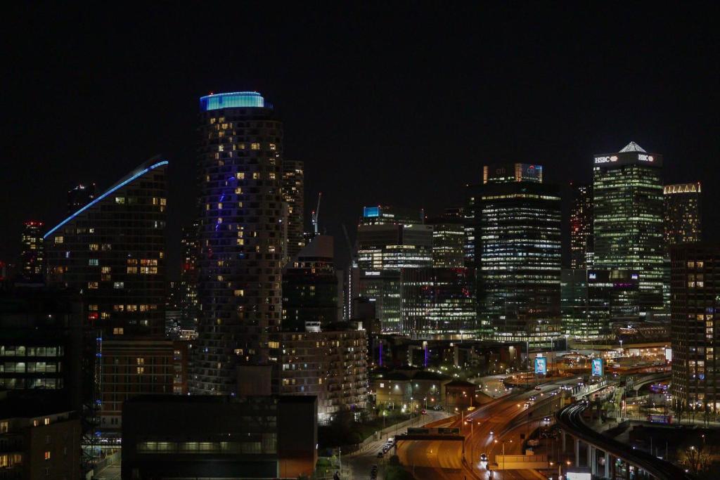 a view of a city at night with at Canary Wharf & O2 in London