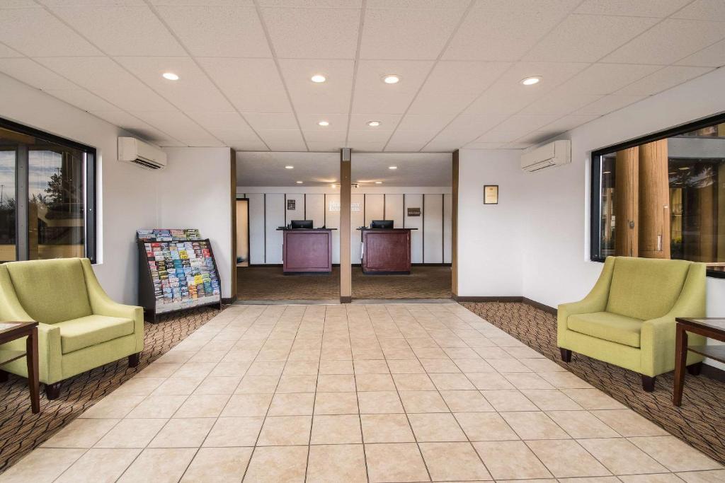an empty lobby with two chairs and a table at Rodeway Inn & Suites Portland - Jantzen Beach in Portland