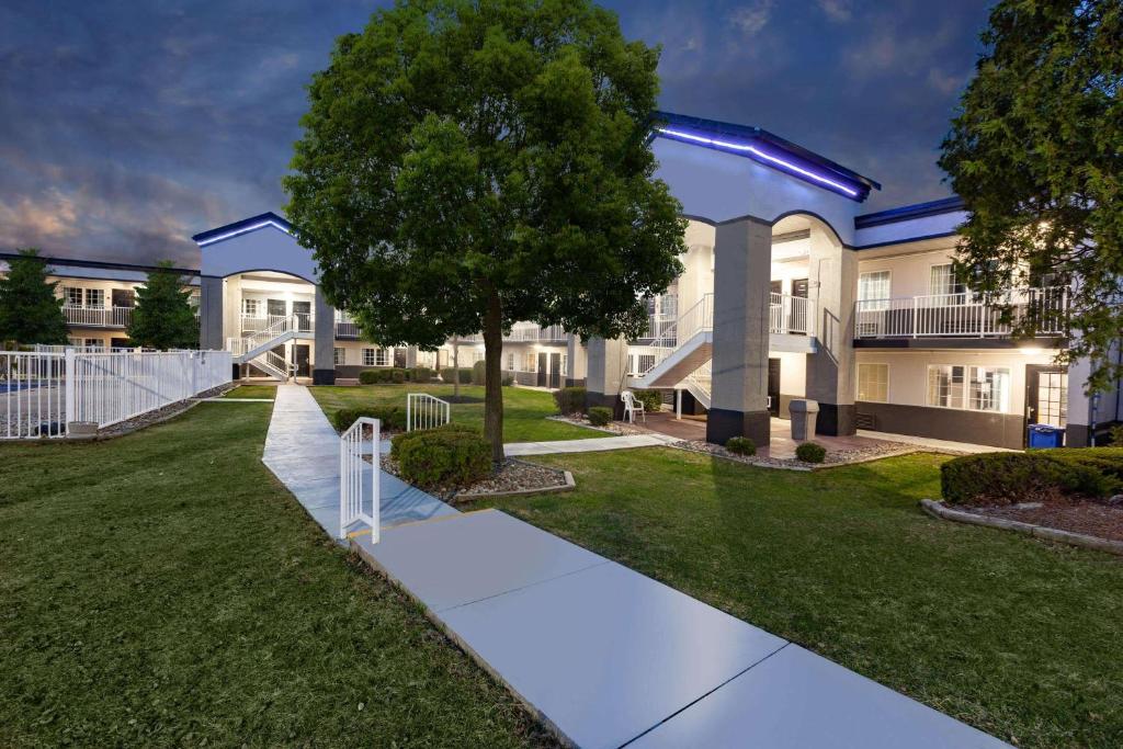 un grand bâtiment avec un arbre en face dans l'établissement Days Inn by Wyndham Austintown, à Austintown