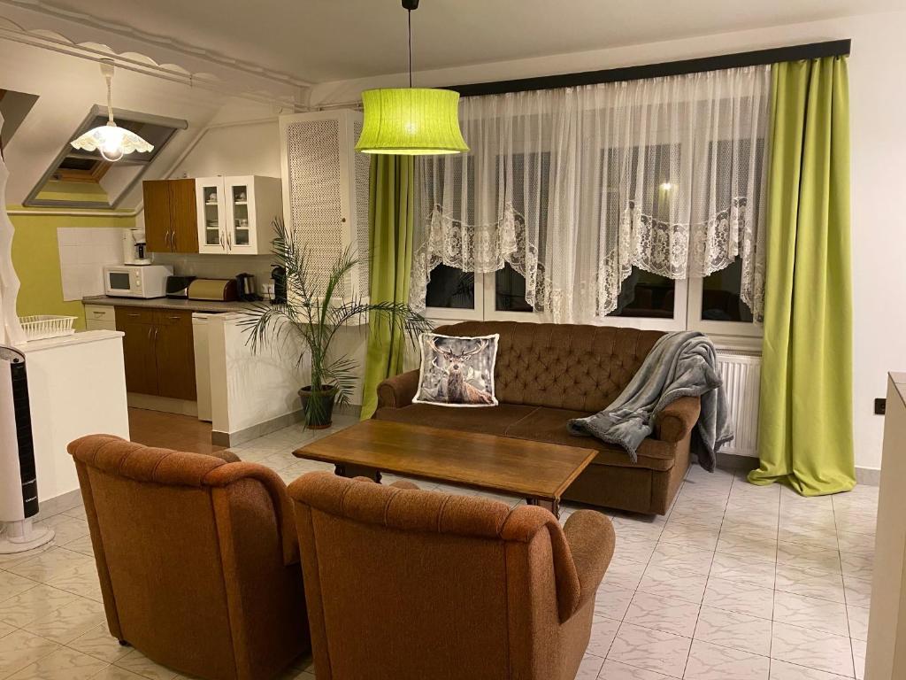 ein Wohnzimmer mit einem Sofa und einem Tisch in der Unterkunft Villa Trófea in Hévíz