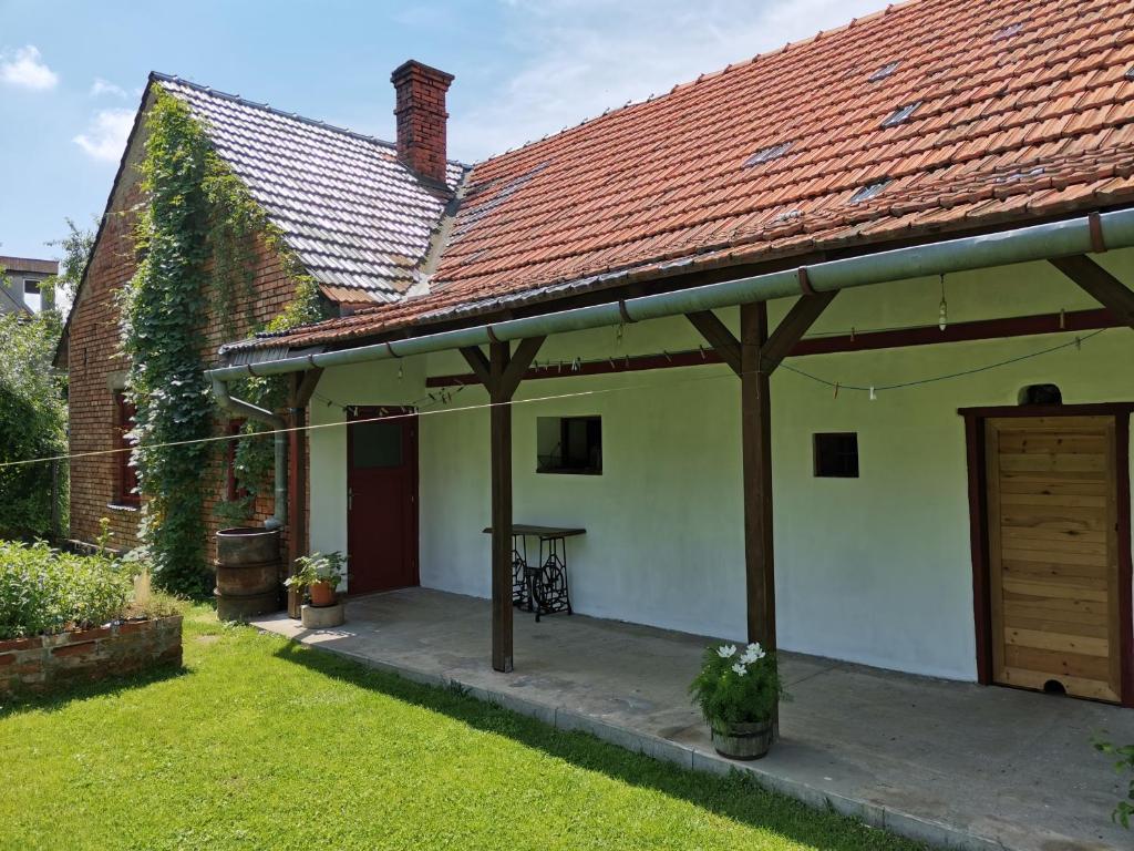 uma casa branca com um telhado vermelho e um pátio em U Páců em Hodslavice