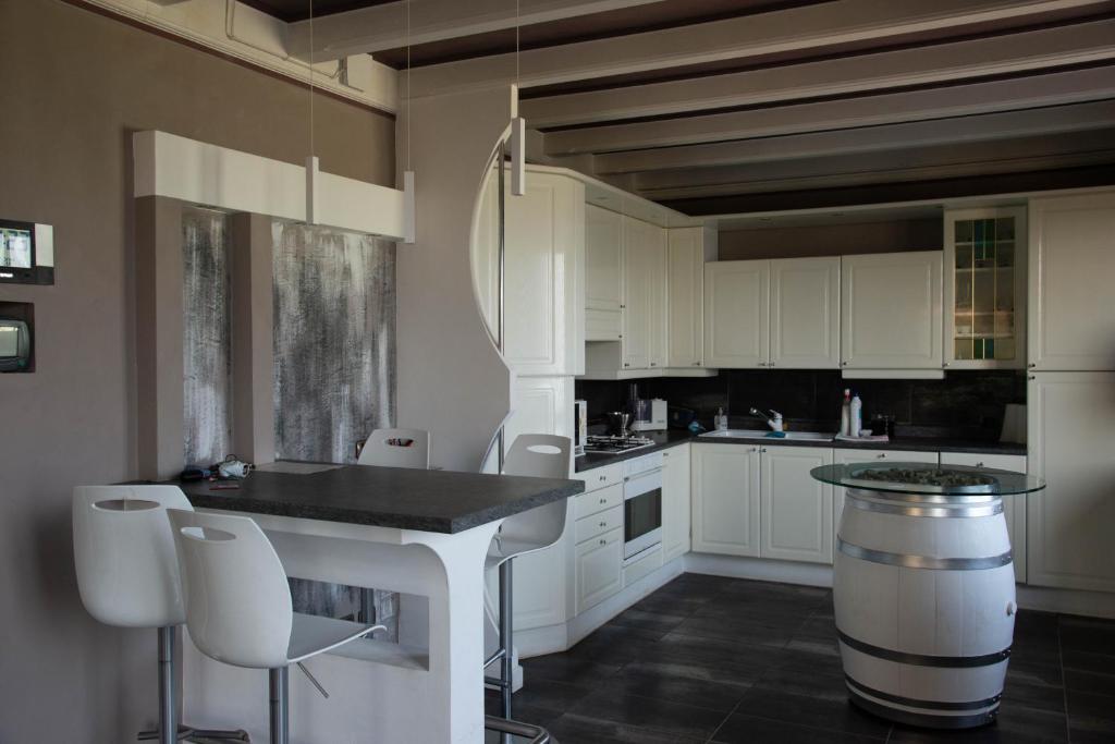uma cozinha com armários brancos e uma mesa e cadeiras em Guesthouse "Villa Tamas" em Limone sul Garda