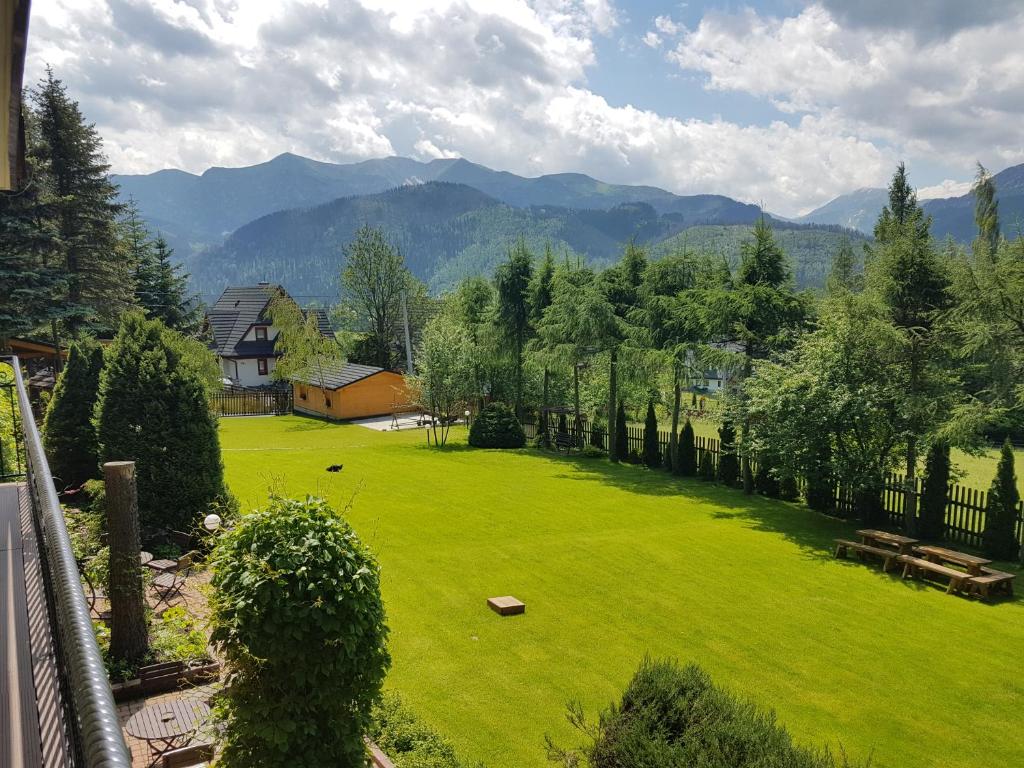 un grand jardin verdoyant avec des montagnes en arrière-plan dans l'établissement Willa Cztery Pory Roku, à Kościelisko