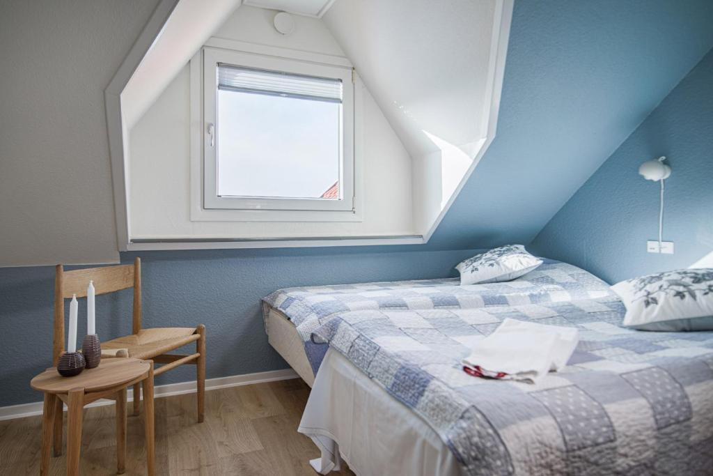 1 dormitorio en el ático con 2 camas y ventana en Hotel Højgaarden, en Slettestrand