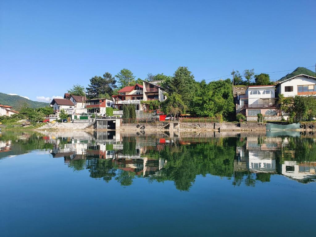 a reflection of houses in a body of water at Apartman Relax Čelebići in Konjic