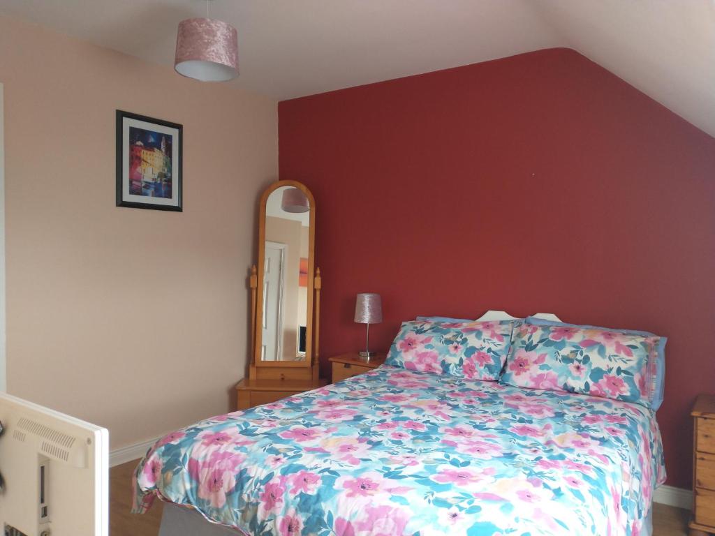 a bedroom with a bed and a mirror at Bundoran Guesthouse in Bundoran