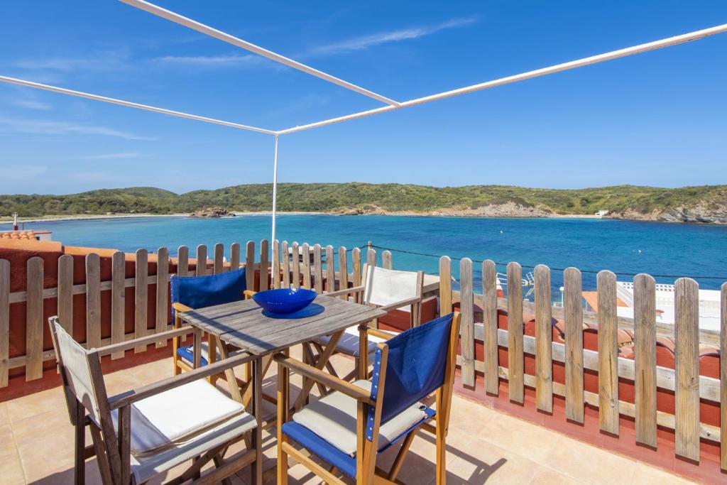 una mesa y sillas en un balcón con vistas al océano en Fantástico apartamento frente al mar en Menorca, en Es Grau