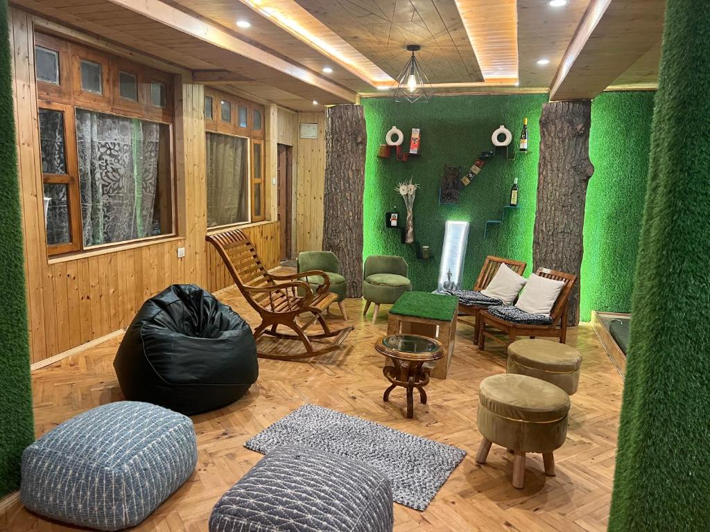 een woonkamer met een groene muur en meubilair bij Pahadi House in Narkanda