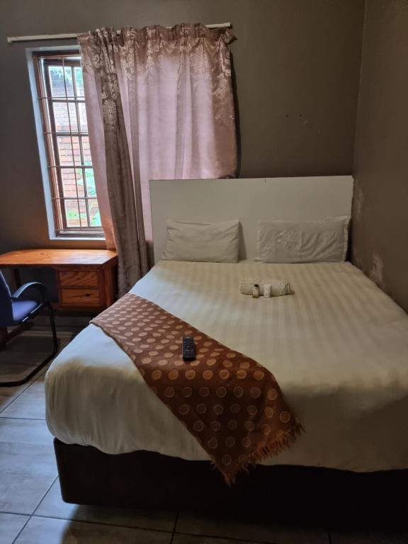 a bedroom with a large white bed with a window at G On M Guest House in Pretoria