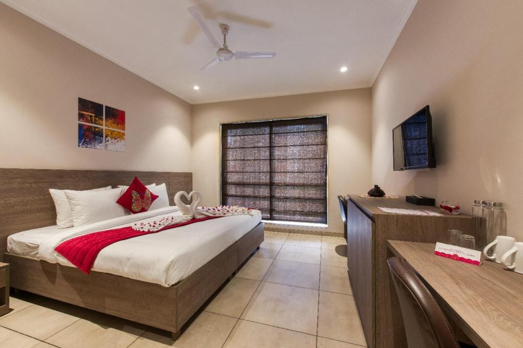 Un dormitorio con una cama grande y una ventana en ROSASTAYS Gurugram Golf Course, en Gurgaon