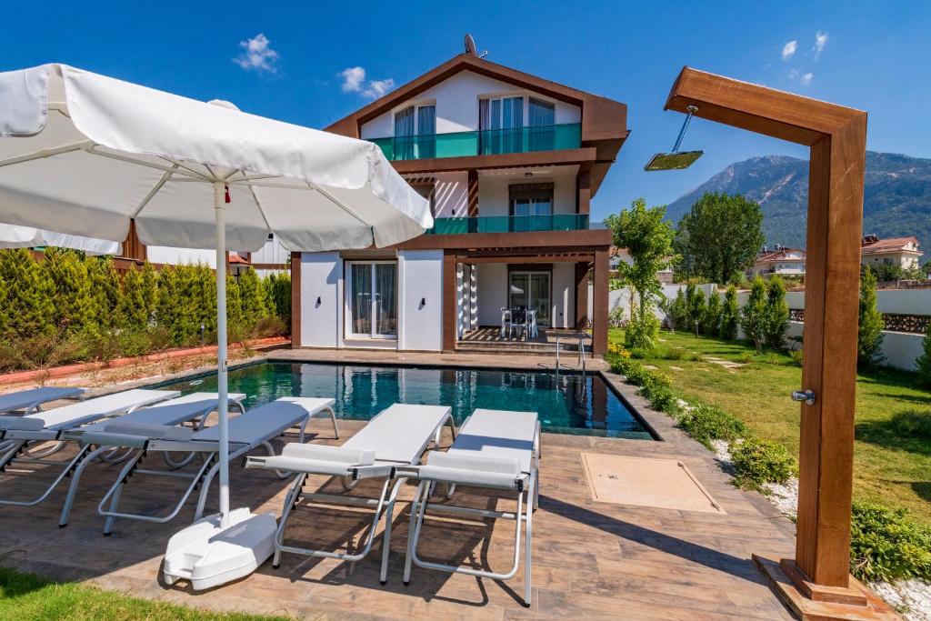 a villa with a swimming pool and a house at 4 Beds, Luxury Holiday Villa in Hisarönü Ölüdeniz Villa Mia in Fethiye