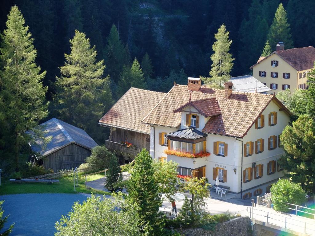 una gran casa en las montañas con árboles en Haus La Punt, Savognin en Rona
