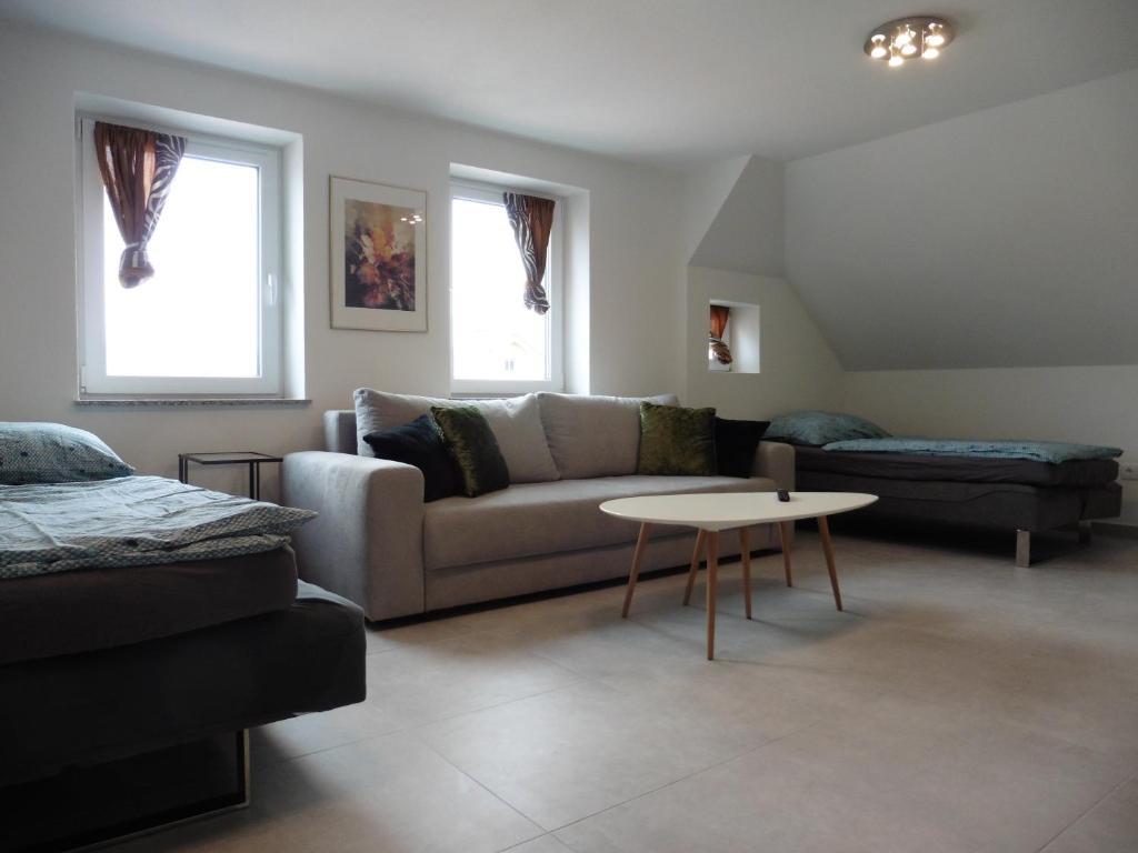 - un salon avec un canapé et une table dans l'établissement Moerth Apartment, à Schalchham