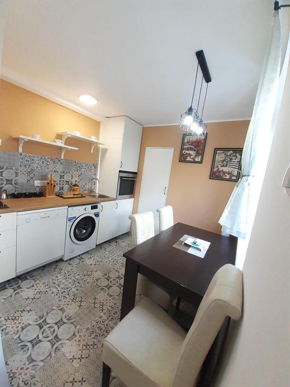a kitchen with a dining room table and a table and chairs at Apartman Jovana in Sremska Mitrovica