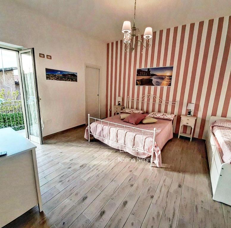 um quarto com uma cama com riscas cor-de-rosa e brancas em La Casa di Nonna Nennella em Santa Maria di Castellabate