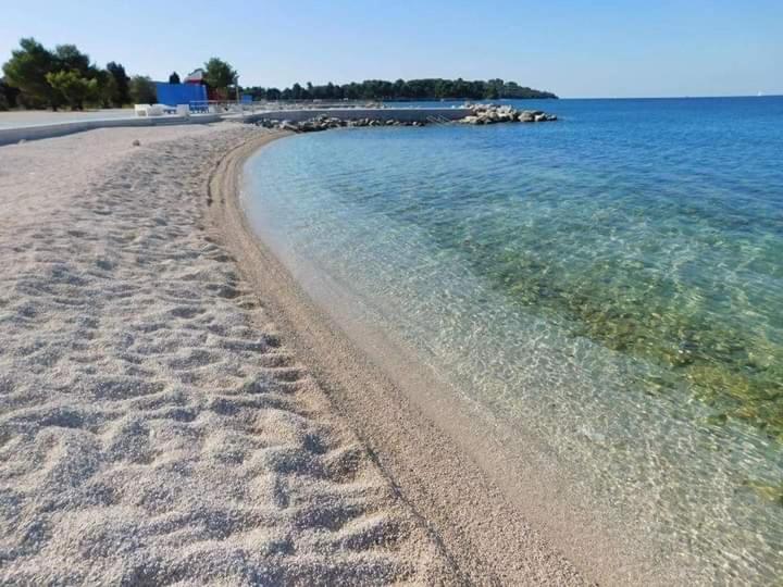 plaża z odciskami stóp w piasku i wodzie w obiekcie Apartment MADIS & Free Bikes w Puli