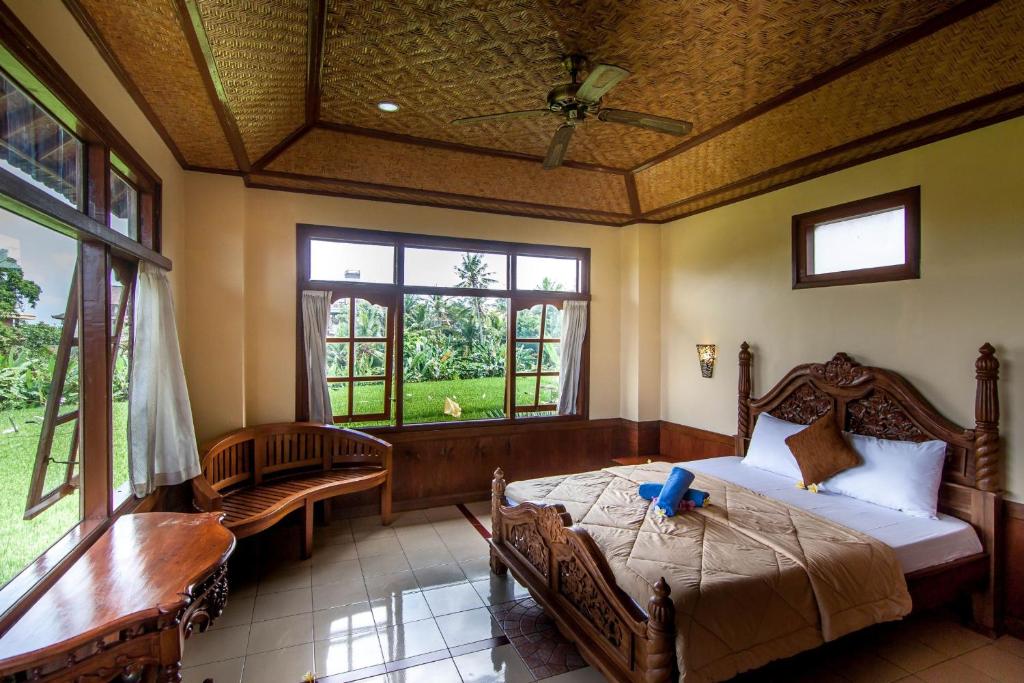 Postel nebo postele na pokoji v ubytování Ganesha Ubud Inn