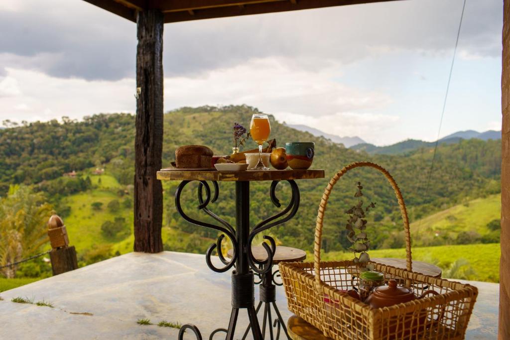 a table on a porch with a view of a mountain at Munay Pousada in Santo Antônio do Pinhal