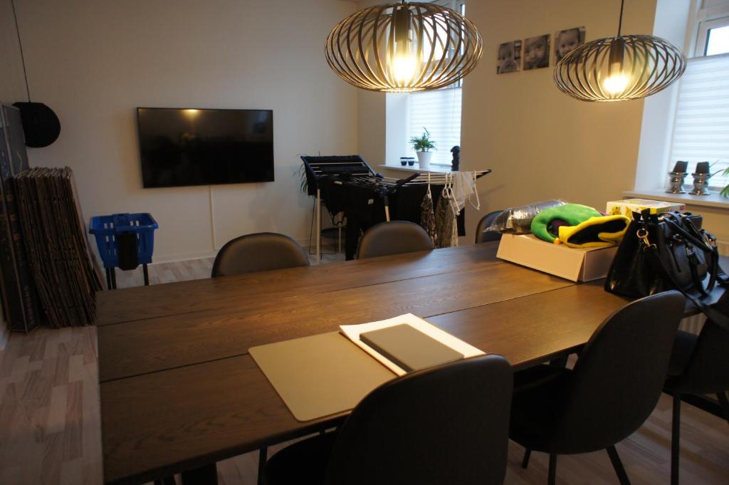 a dining room with a table with chairs and a television at 87 Østergade (id. 051) in Esbjerg