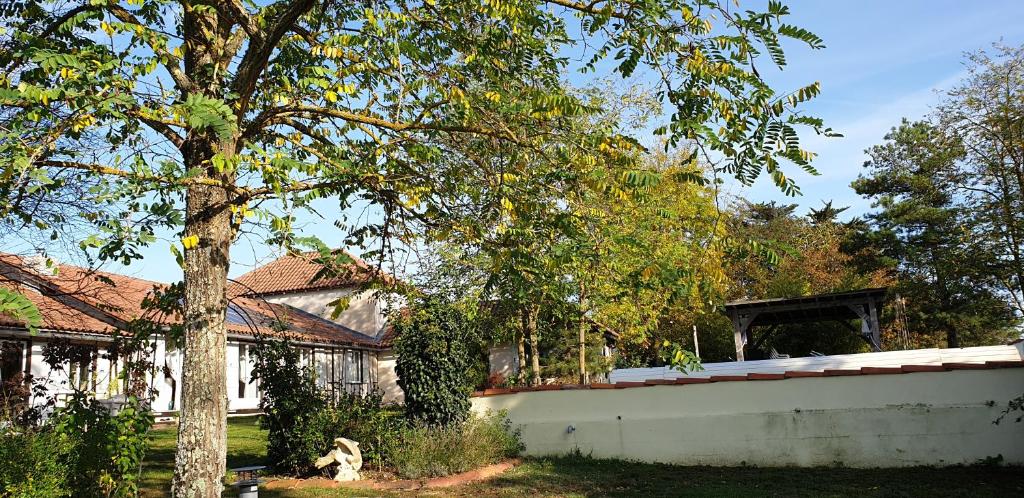 a house with a tree in the yard at CHAMBRE D'HOTE 40 M2 très agréable 