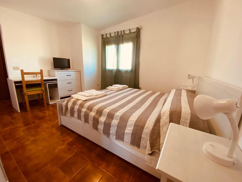 1 dormitorio con 1 cama y escritorio con ordenador en Good Vibe Sardinia B&B, en Olbia