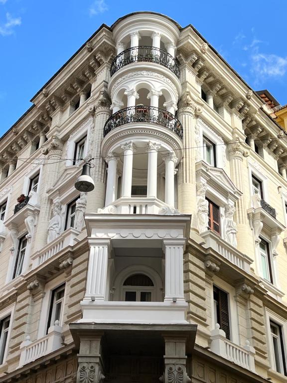 a large white building with a balcony on it at Hotel Le Petit in Rome