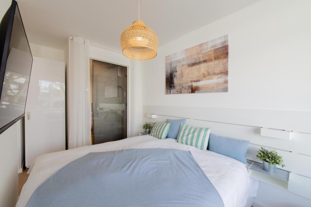 ein Schlafzimmer mit einem großen Bett mit blauen Kissen in der Unterkunft Ferienwohnung Ocean Lodge Travemünde in Travemünde