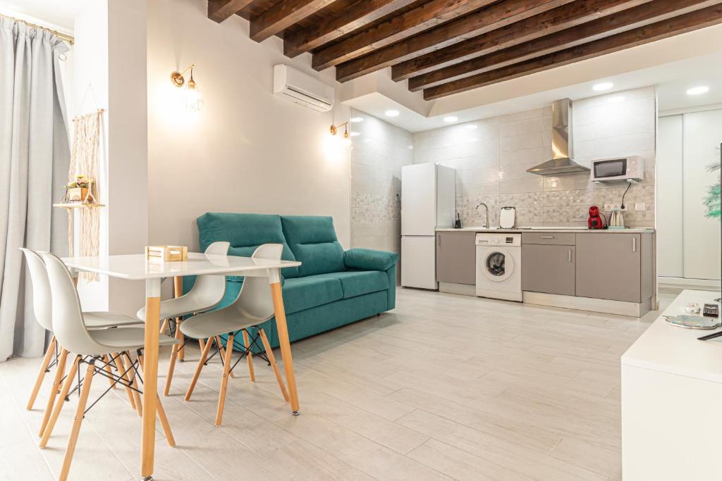 een woonkamer met een tafel en een groene bank bij Allo Apartments Plateros Centro in Jerez de la Frontera