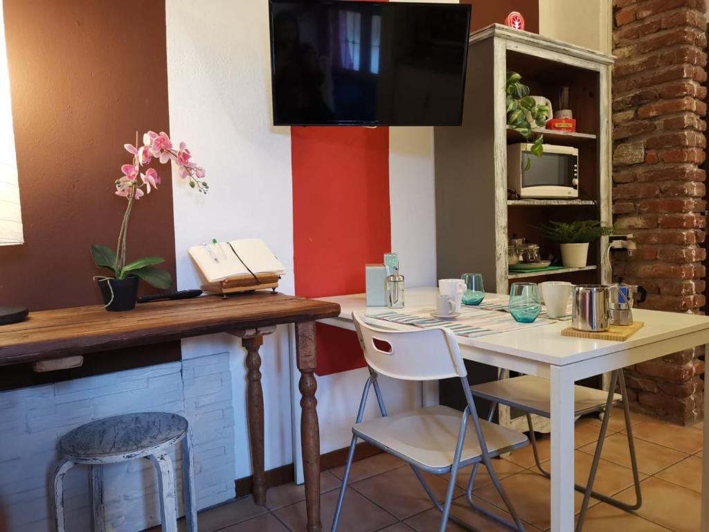 a dining room with a table and a tv at Bnbook Il Geco in Olgiate Olona