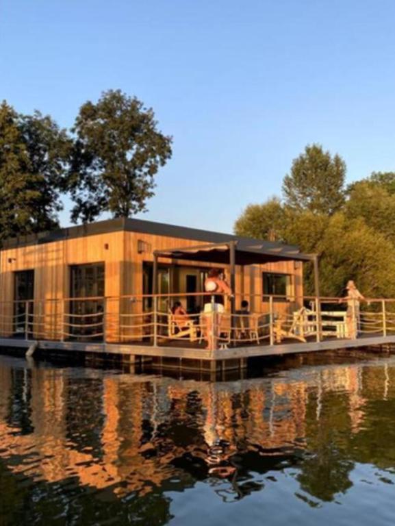une maison sur un quai sur un plan d'eau dans l'établissement SeineHouse - Maison flottante (HouseBoat) - Séjour magique sur l'eau, à Vaux-sur-Seine