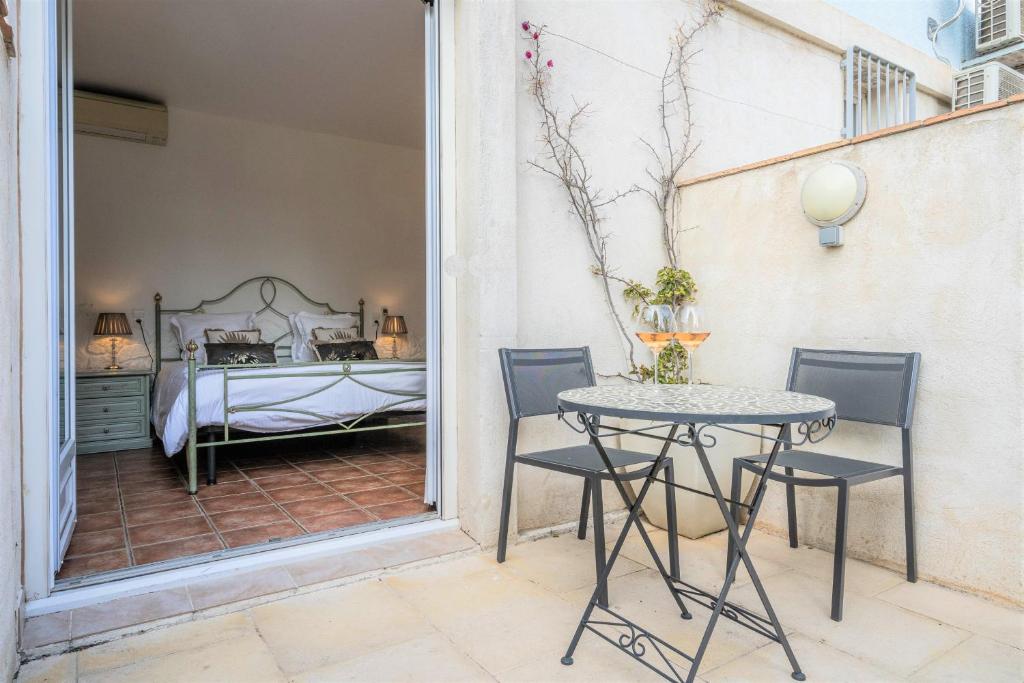 - une chambre avec un lit, une table et des chaises dans l'établissement Hôtel Le Méditerranée, à Hyères