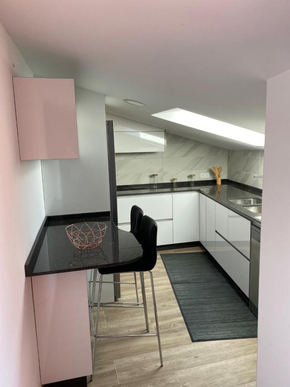 a kitchen with a black table and a chair at Ático en pleno centro en Cangas in Cangas de Morrazo