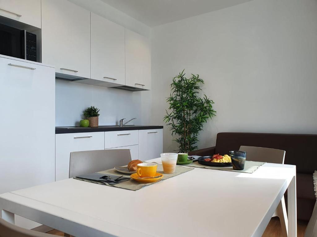 uma cozinha branca com uma mesa branca com comida em Superior Beach Aparthotel em Lido di Jesolo