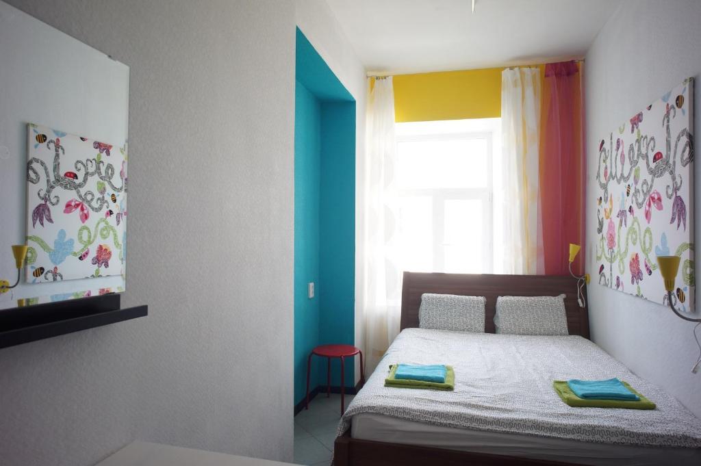 Habitación pequeña con cama y ventana en Vitamin Rooms, en San Petersburgo