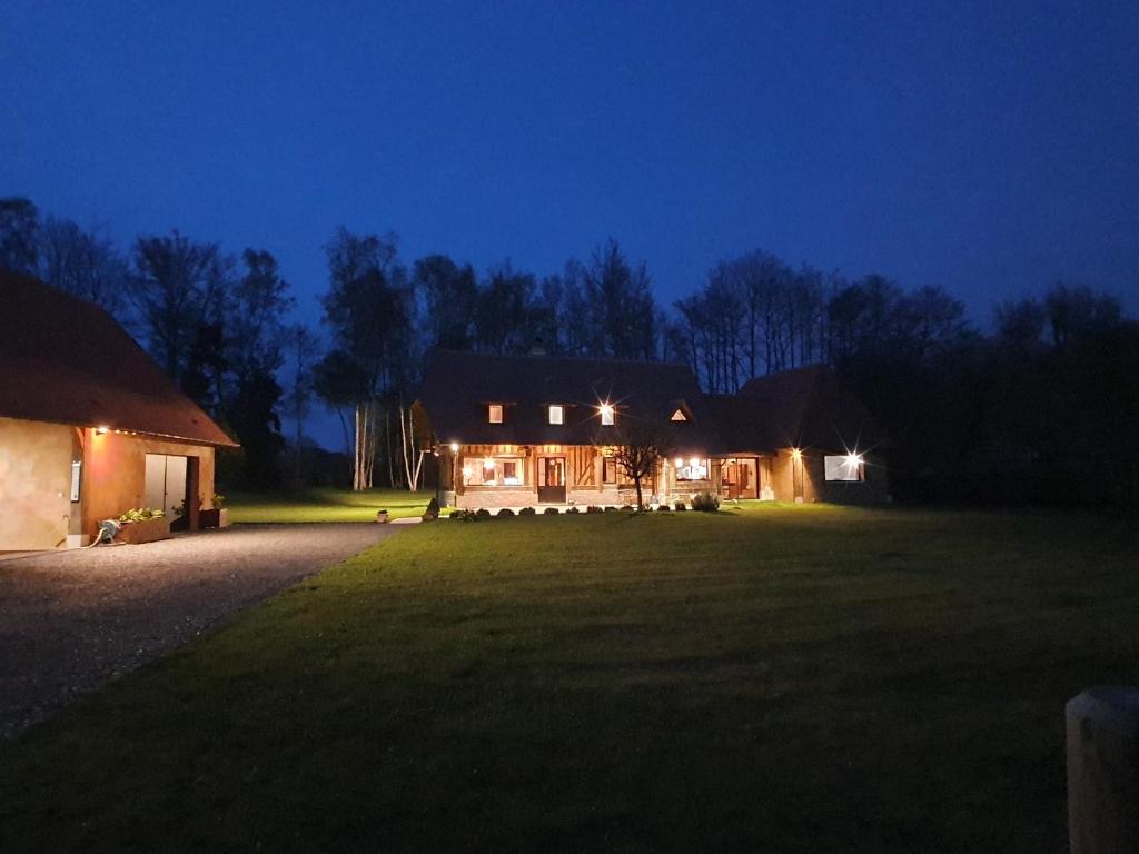 una casa su un campo di notte con luci di LE CLOS JOLY 14 a Saint-Gatien-des-Bois