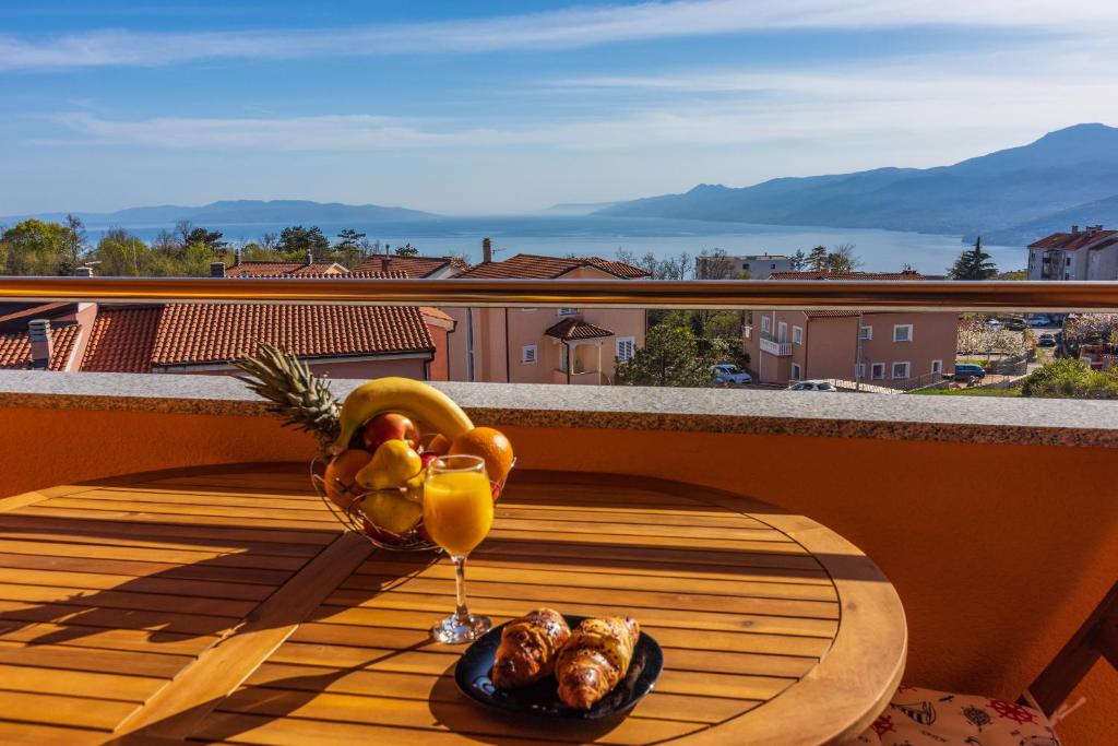 einen Tisch mit einer Schale Obst und einem Glas Orangensaft in der Unterkunft Apartment Villa Sea Star in Kastav