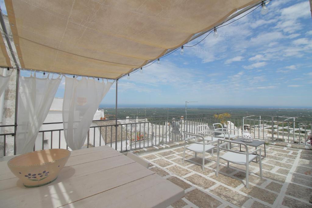 un patio con tavoli, sedie e vista sull'oceano di La Poma a Ostuni