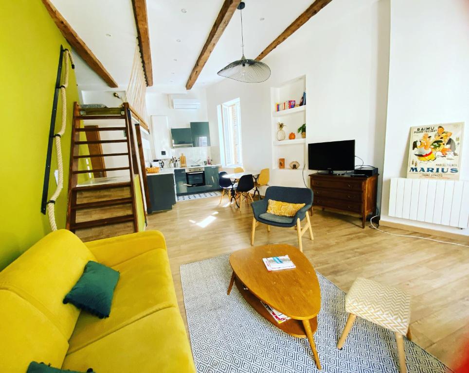 uma sala de estar com um sofá amarelo e uma mesa em Vaste et charmant loft CLIMATISÉ au cœur de Marseille em Marselha