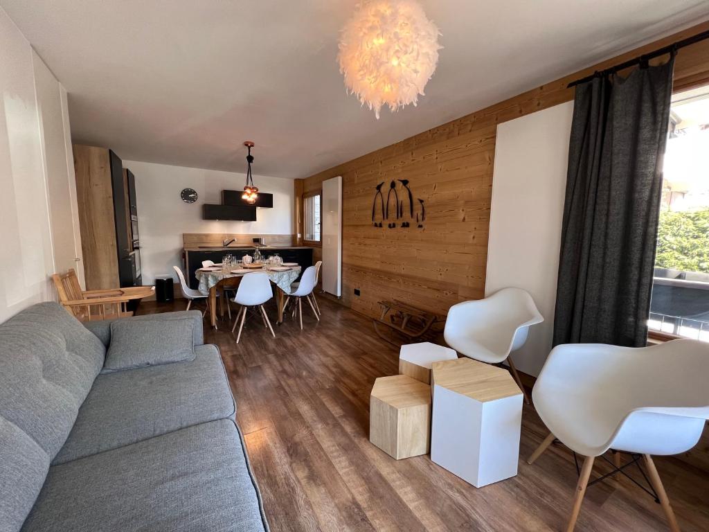 a living room with a couch and a dining room at Elan 12 - Très bel appartement centre village in La Clusaz