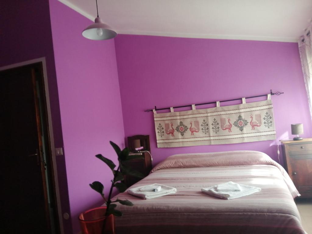 AlesにあるB&B Daddancaの紫の壁のベッドルーム1室、ベッド1台(タオル2枚付)