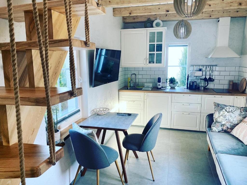 een keuken en een woonkamer met een tafel en stoelen bij Vila Preiloja - Žvejo namelis in Neringa