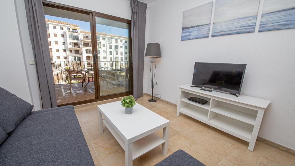 un soggiorno con divano, TV e tavolo di Lovely 2-Bed Apartment in Marina de la Duquesa a Castillo de Sabinillas