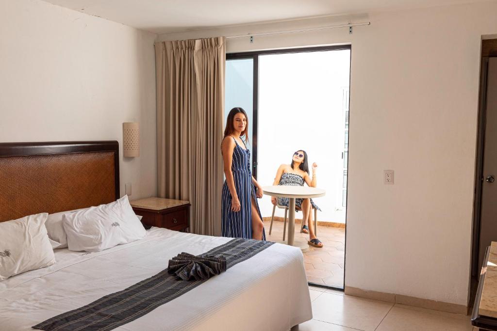 a woman standing in front of a bed in a hotel room at Hotel María Jose in Mérida