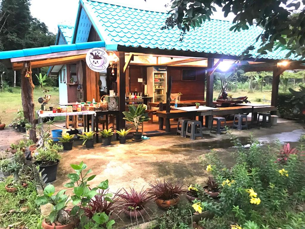 een huis met een tafel en wat planten bij kohkoodfarmstay in Ban Ao Yai