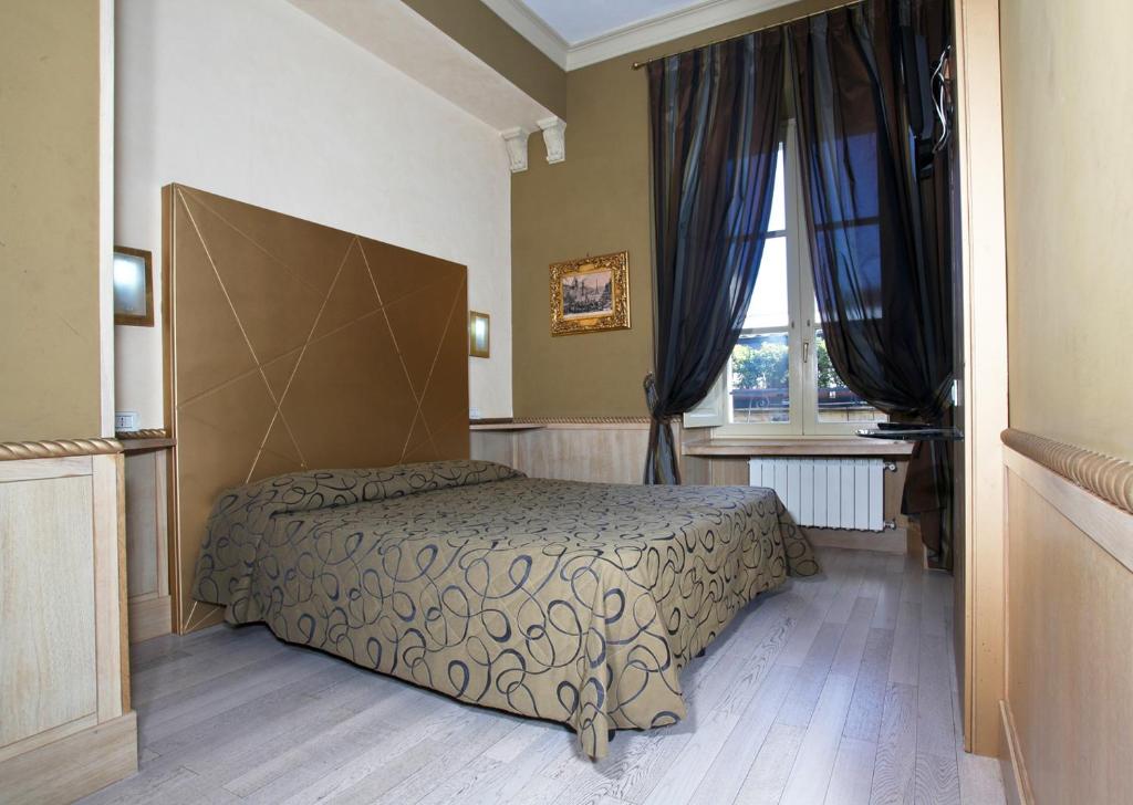 a bedroom with a bed and a window at Hotel Nardizzi Americana in Rome