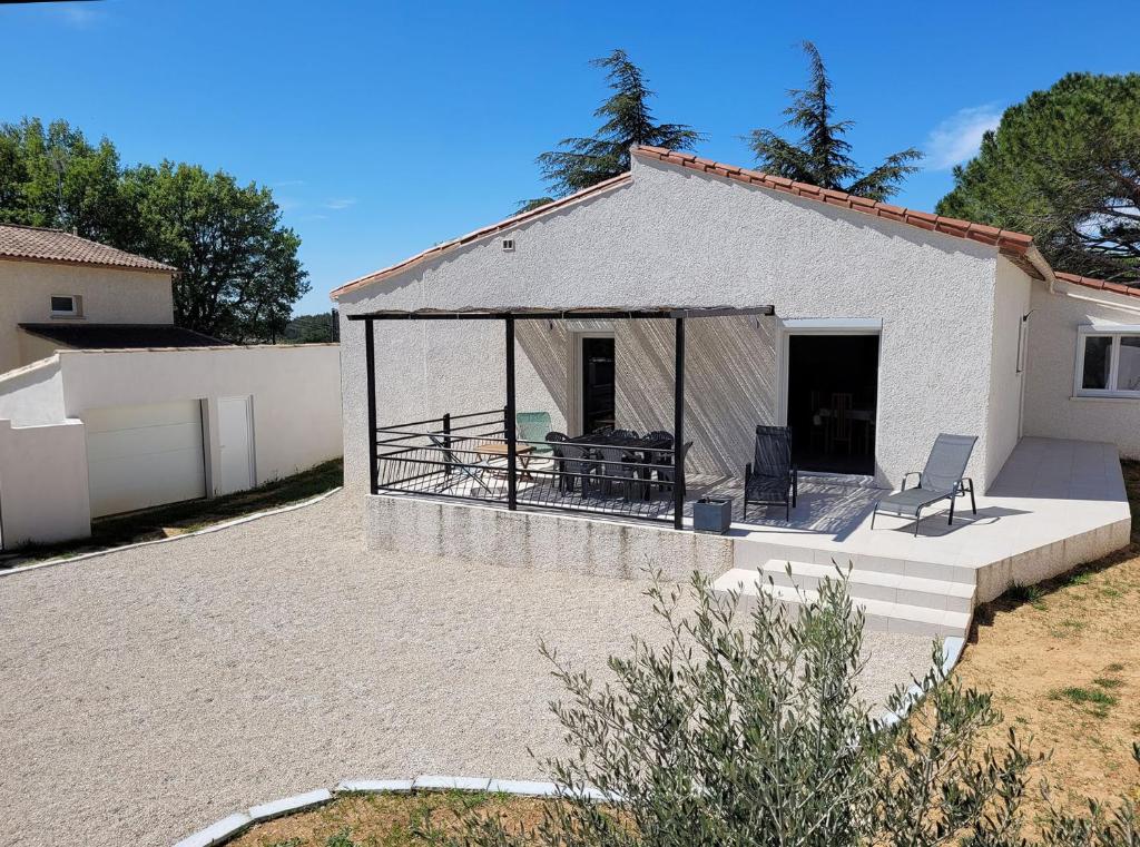 Cette maison blanche dispose d'une terrasse avec 2 chaises. dans l'établissement Villa entière de 145m² calme en petite Camargue, à Beauvoisin