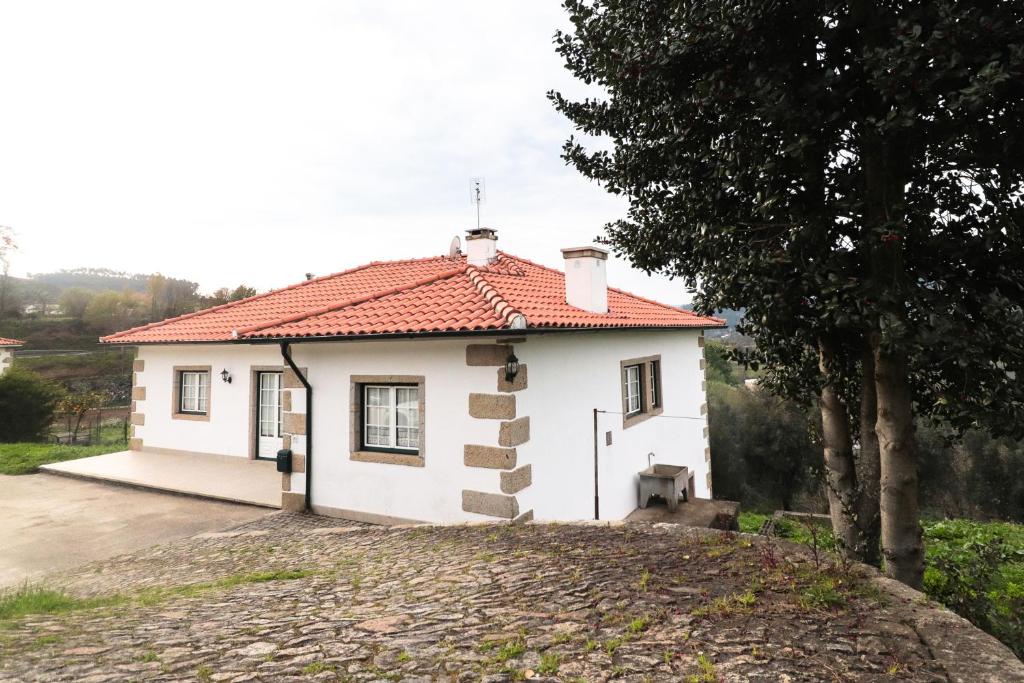 een klein wit huis met een rood dak bij Casa da BellaVista in Ponte de Lima