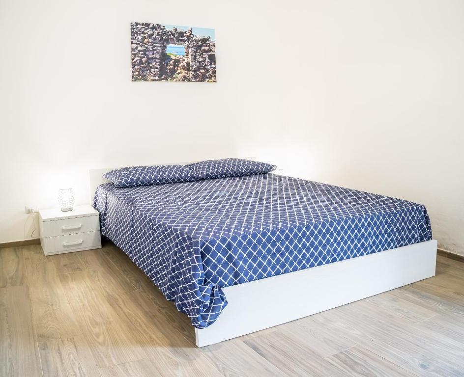 a bedroom with a bed with a blue and white bedspread at Casa al mare Le Dune in Lido Marini